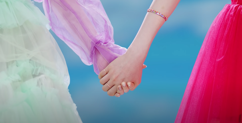 NiziU em cena doe mãos dadas no MV do single "Step and a Step"