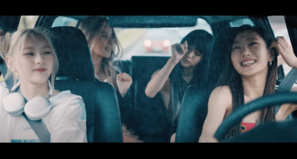Cena do MV de Shhh, KISS OF LIFE, com Haneul, Belle, Natty e Julie se divertindo no carro