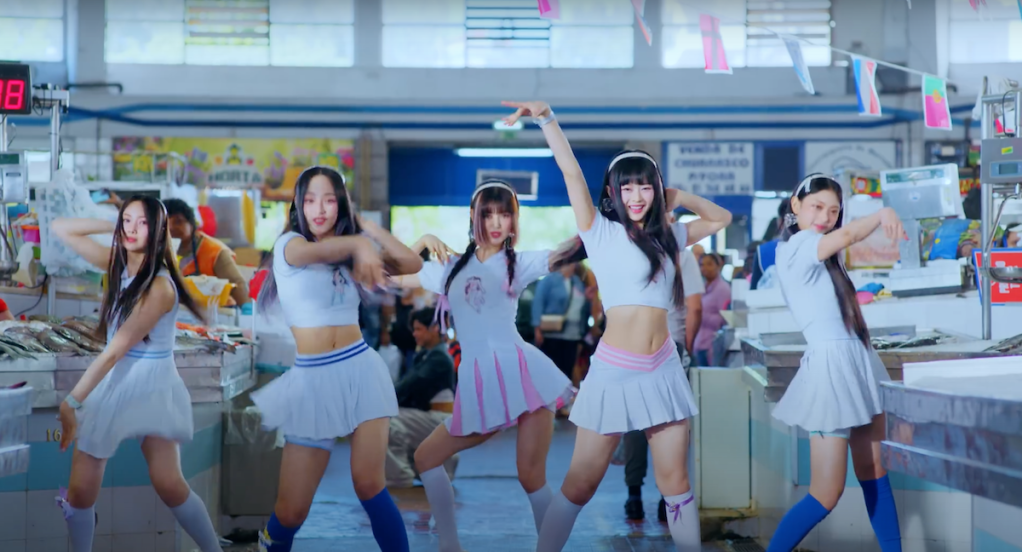 Cena do grupo NewJeans dançando para a música Super Shy do álbum Get Up