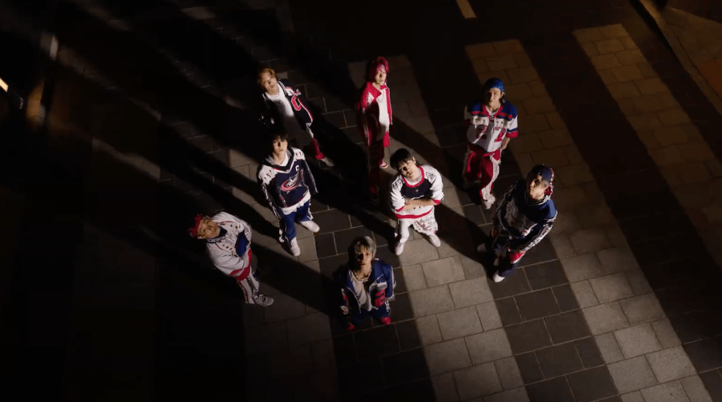 Cena do MV de Fact Check do novo álbum Fact Check do NCT 127, com todos os membros olhando para cima