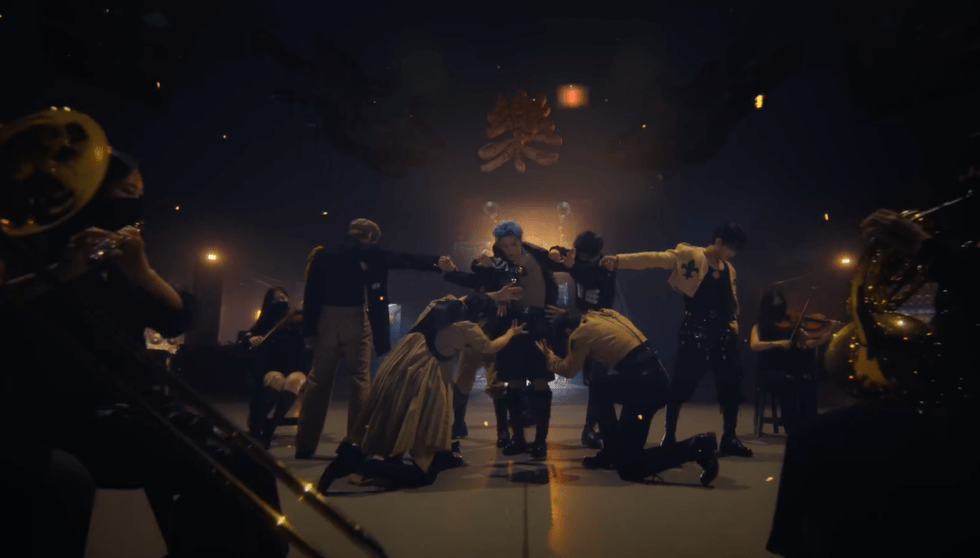 Cena do MV de "LALALA" do álbum 樂-STAR com os meninos do Stray Kids no centro, Felix no meio e os demais na volta