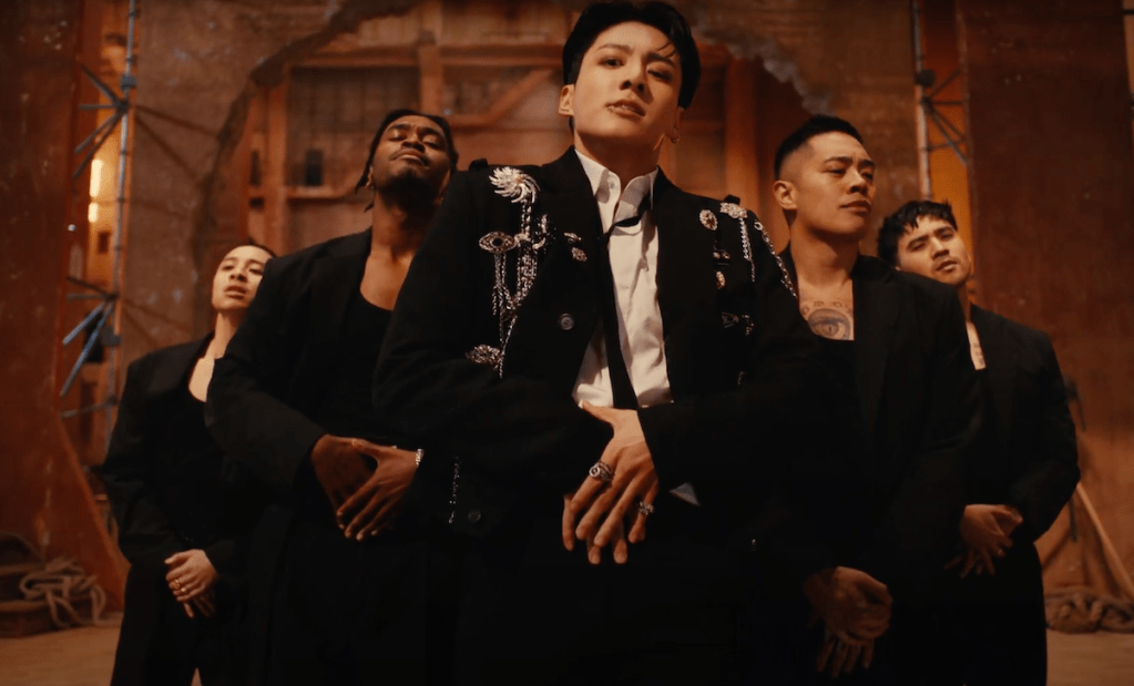 Cena do MV de "Standing Next to You" do album Golden com Jungkook em close dançando ao lado de outros dançarinos