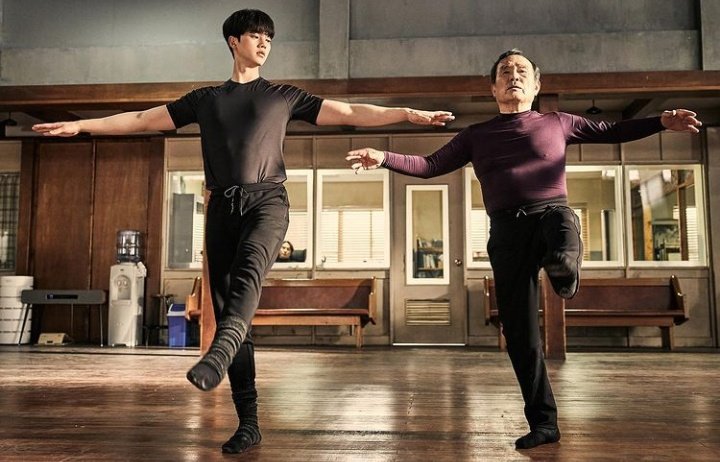 Cena do K-Drama Navillera com Deok-Chul e Chae-Rok ensaiando passos de balé no estúdio, um ao lado do outro