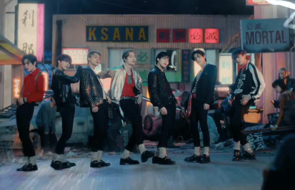 Cena do MV de "Sweet Venom", titletrack do álbum Orange Blood do ENHYPEN com o grupo no centro, em pose para a câmera