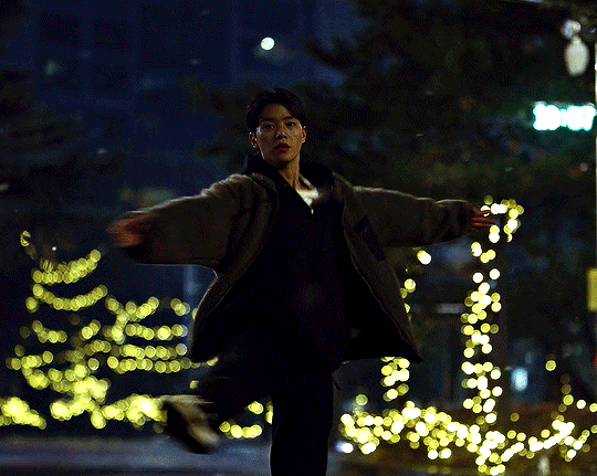 Cena do K-Drama Navillera com Chae-Rok dançando balé na neve e luzes de Natal ao fundo