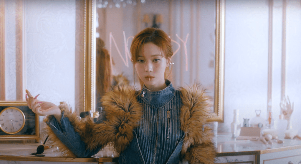 Cena do MV de "Nobody" com Winter do grupo aespa sentada na frente de um espelho