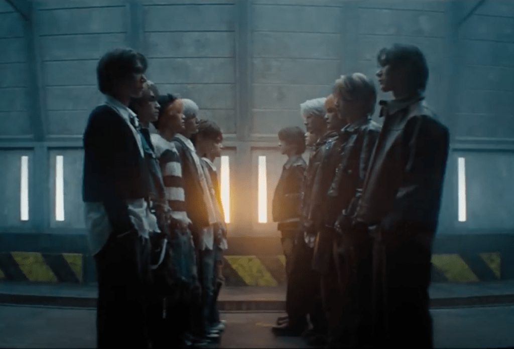 Cena do MV de "On My Youth" com os meninos do WayV em fila olhando para "clones"