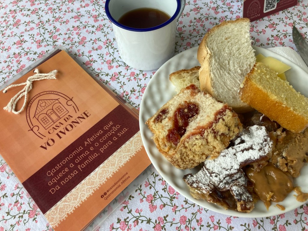 Prato na mesa com pães, cuca e tortas na Casa da Dona Ivonne no Pé da Cascata do Caracol