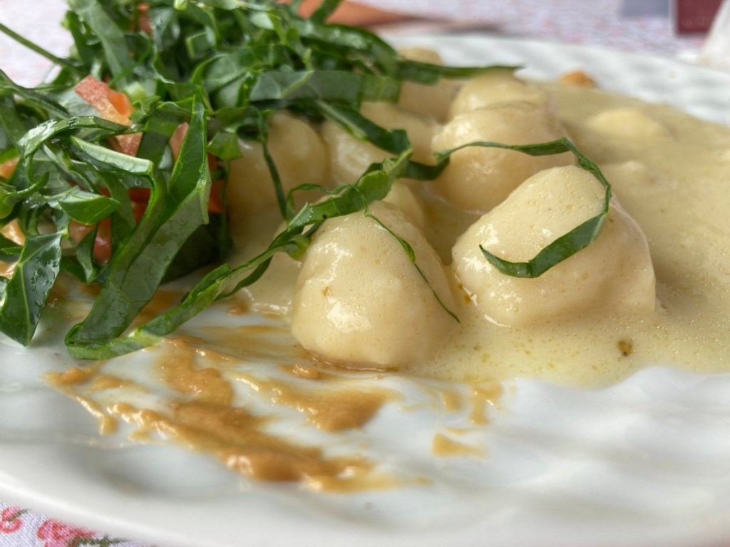 Prato na mesa com nhoque e salada na Casa da Dona Ivonne no Pé da Cascata do Caracol