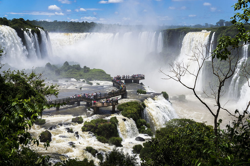 Turismo ecológico: passarela cheia de pessoas no meio das águas das Cataratas do Iguaçu em Foz do Iguaçu (PR)