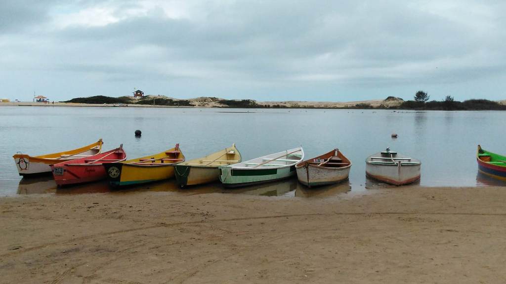 Turismo ecológico: barcos coloridos lado a lado nas margens do Rio da Madre na Guarda do Embaú (SC)