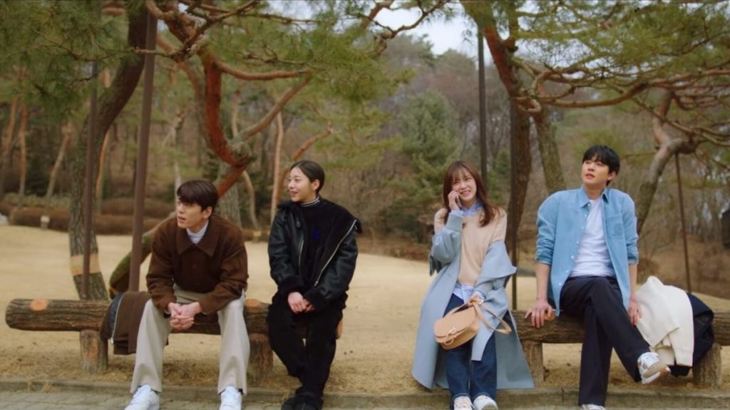 Cena do K-Drama Business Proposal com Sung-Hoon, Young-Se, Ha-Ri e Tae-Moo sentados em um banco de madeira no parque