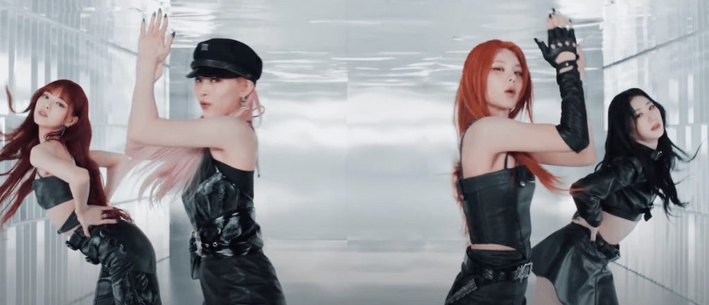 Cena do MV de UNTOUCHABLE do álbum Born to Be com as meninas do Itzy — Chaeryeong, Yuna, Ryujin e Yeji — dançando em um fundo branco enquanto olham para a câmera