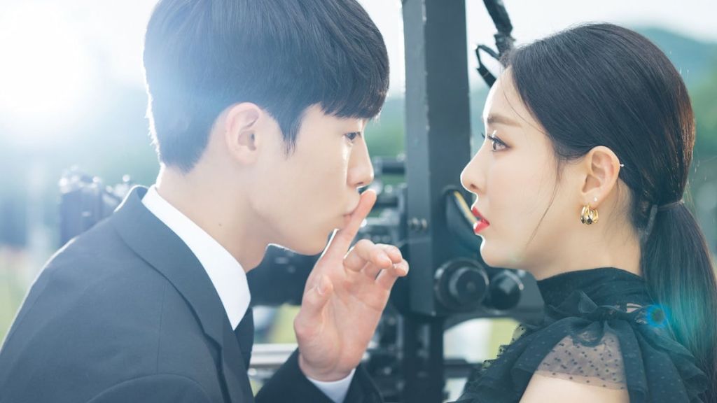 Cena do K-Drama Search: WWW com Scarlett olhando para o Ji-Hwan, que faz um gesto para que ela fique em silêncio