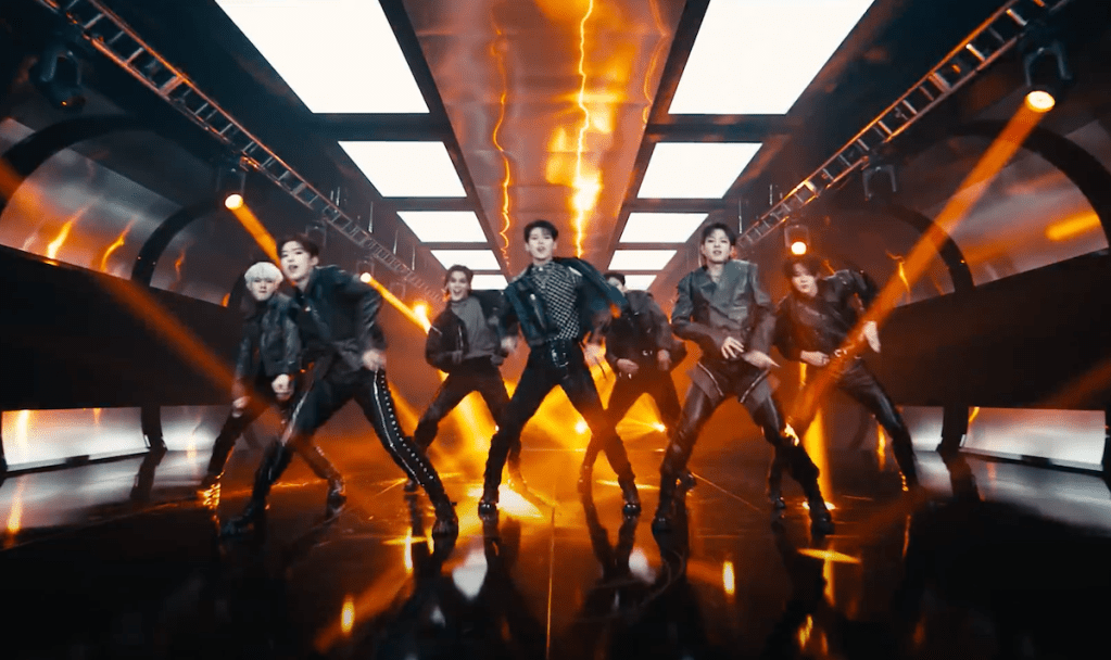 Cena do MV de "UGLY" do álbum Un: SEEN do EVNNE com os seis membros dançando em meio a efeitos especiais de luzes