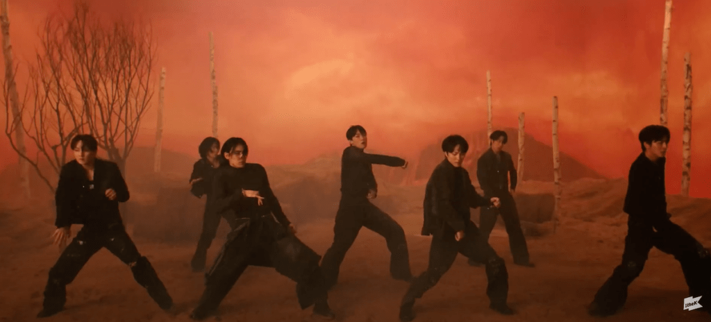 Cena do MV de "BIBORA" do álbum Sequence com os membros do SF9 dançando em um cenário todo laranja