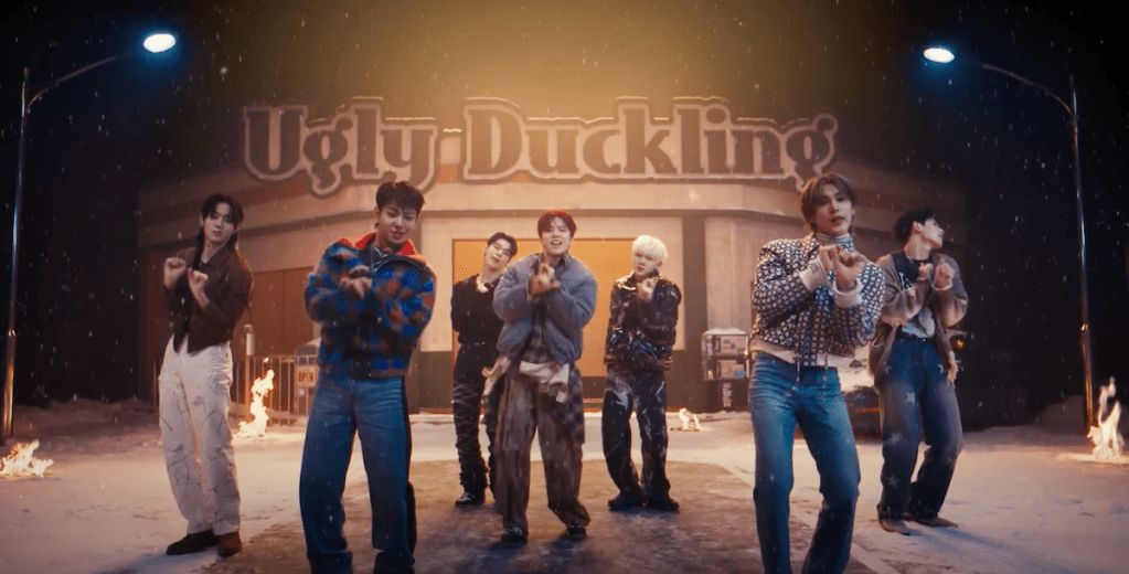 Cena do MV de "UGLY" do álbum Un: SEEN do EVNNE com os membros olhando para a câmera enquanto dançam