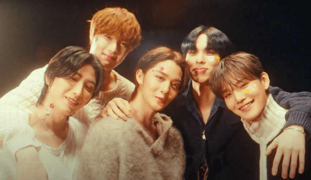 Cena do MV de "Lovers or Enemies" do álbum 0 or 1 do CIX, com os membros olhando e sorrindo para a câmera