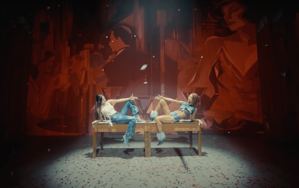 Cena do MV de "No More (Ma Boy)" para o comeback do SISTAR19 com Bora e Hyolin deitadas em uma mesa de madeira