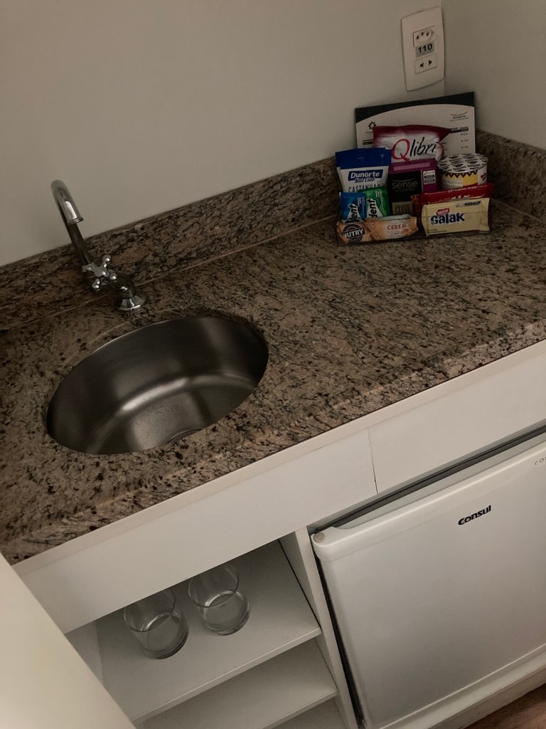 Pequena cozinha com pia e frigobar no hotel Transamerica Executive Perdizes em São Paulo