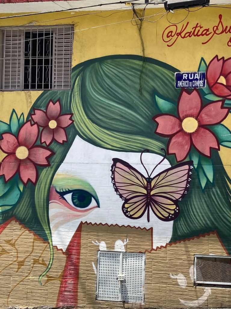 Arte urbana com imagem do rosto de uma japonesa com uma borboleta em um dos olhos no bairro Liberdade em São Paulo