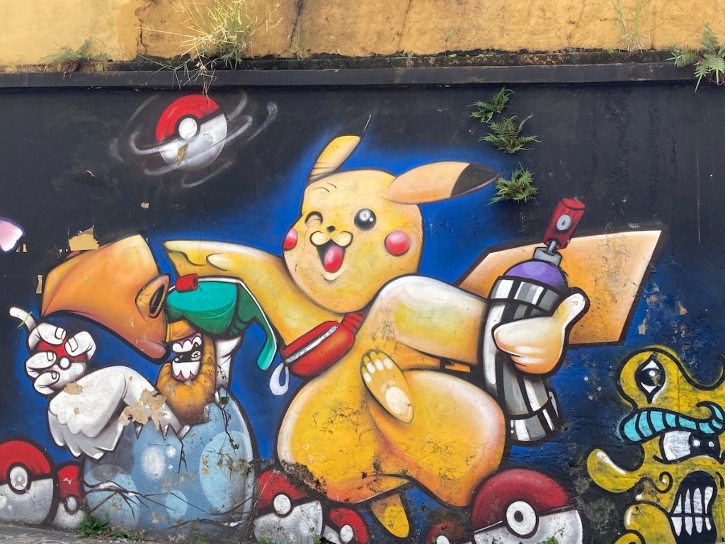 Arte urbana com imagem do Pikachu e várias pokébolas no bairro Liberdade em São Paulo