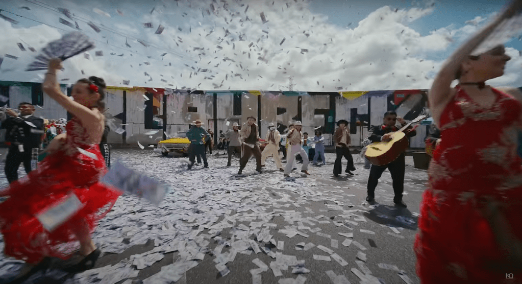 Cena do MV de "WORK" do álbum Golden Hour: Part.1 com todos os membros do ATEEZ dançando enquanto notas de dinheiro caem do céu