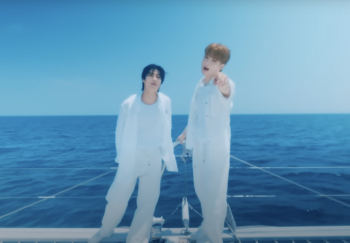 Cena do clipe especial para o single "Into You" do N.Flying com Seung Hyub e Hwe Seung em um barco, mar ao fundo e céu azul