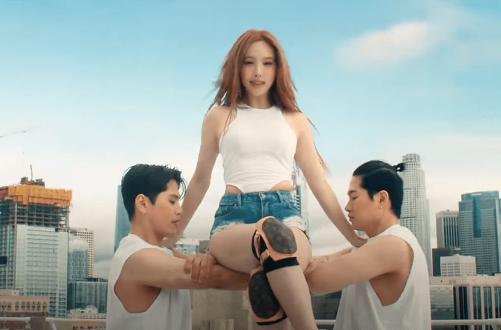 Cena do MV da música ABCD do álbum NA da Nayeon em primeiro comeback solo. Ela levantada por dançarinos no topo de um prédio