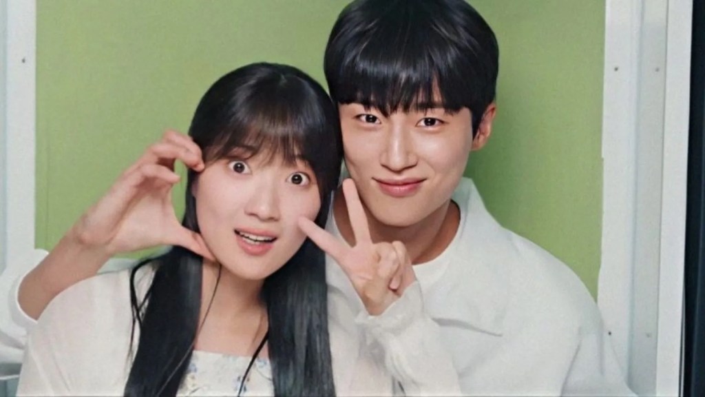 Cena do K-Drama Lovely Runner com Sun Jae e Im Sol fazendo pose para fotos em uma cabine fotográfica