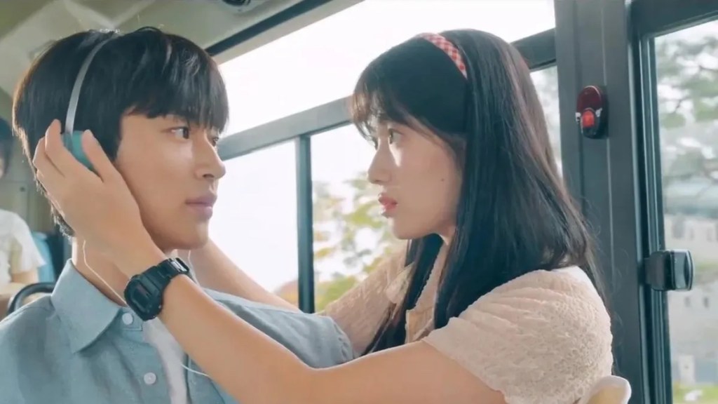 Cena do K-Drama Lovely Runner com Im Sol colocando fones no Sun Jae enquanto os dois estão dentro de um ônibus