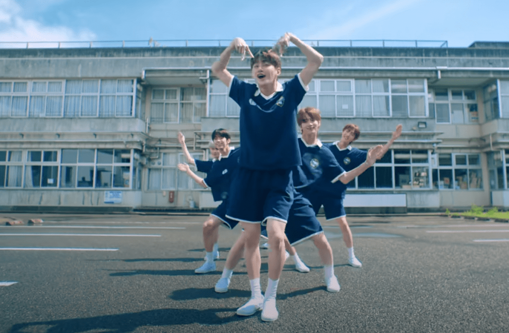 Cena do MV de "If I'm S, Can You Be My N?" do álbum SUMMER BEAT com todos os membros dançando em fila ao ar livre