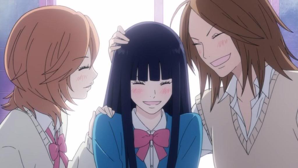 Imagem do anime Kimi ni Todoke com Sawako Kuronuma sorrindo e com o rosto vermelho, cercada por Ayane do lado esquerdo e Chizuru do lado direito