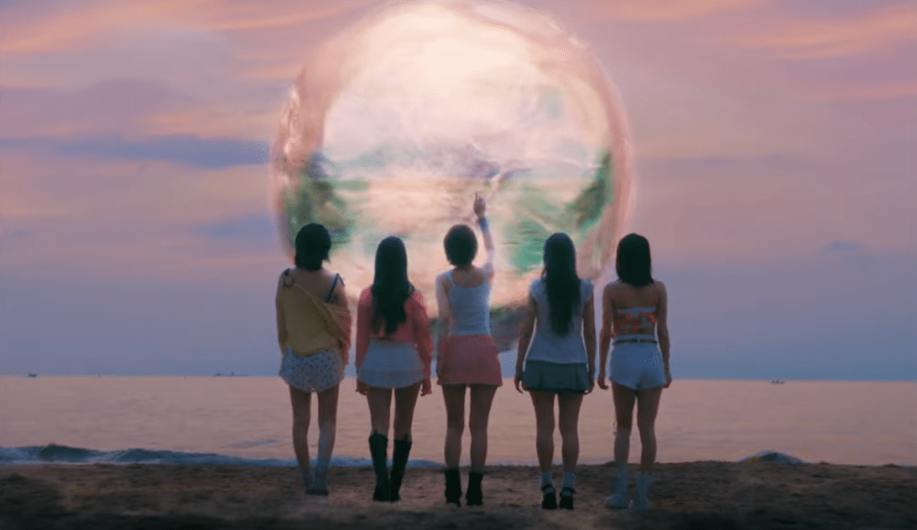 Cena do MV de "I DO I DO" do KARA com Jiyoung, Nicole, Seungyeon e Youngji de costas para a câmera, olhando uma bolha misteriosa