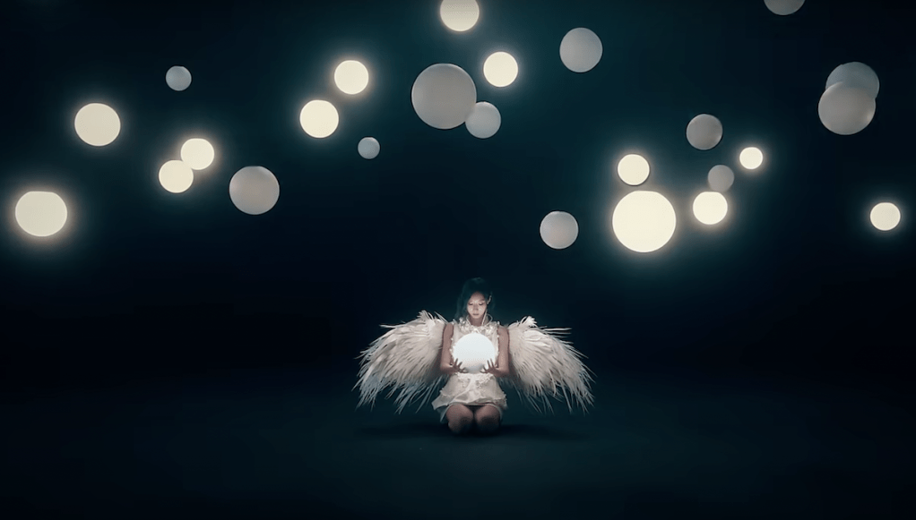 Cena do MV de "JUSTICE" do álbum [VirtuouS] do Dreamcatcher com efeitos de brilhos e asas de anjo