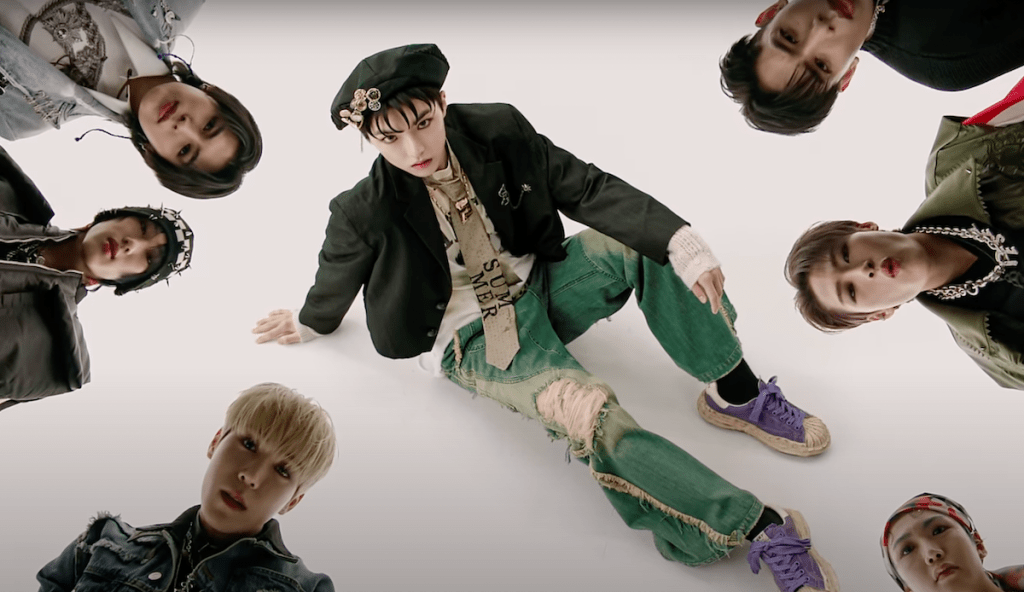 Cena do MV de "도깨비(SHOCK)" do álbum WITNESS do ALL(H)OURS com todos os membros em foco olhando para a câmera em um fundo branco