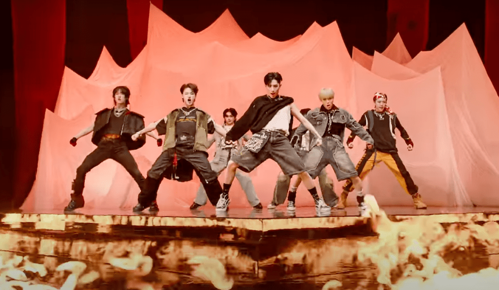 Cena do MV de "도깨비(SHOCK)" do álbum WITNESS do ALL(H)OURS com coreografia em um palco em chamas