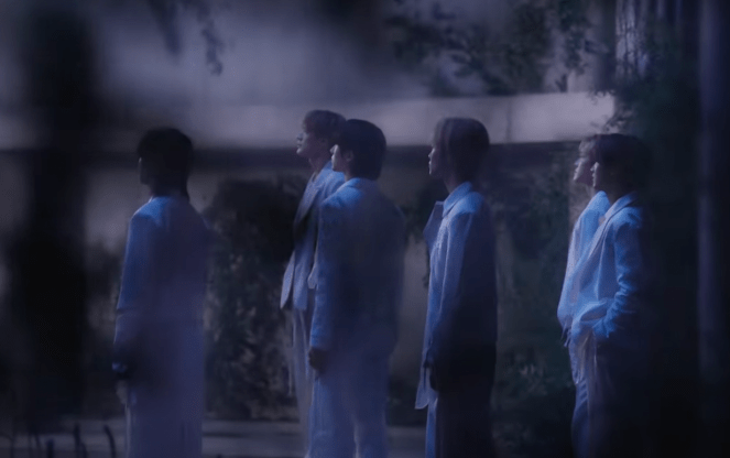 Cena do MV de "Rains in Heaven", single em inglês do NCT Dream com os membros levemente desfocados pela câmera 