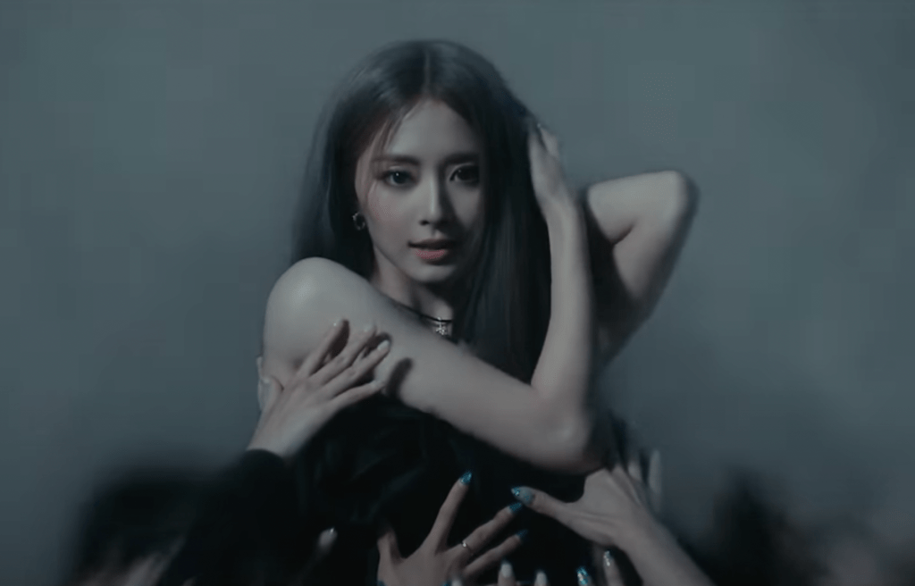 Cena do MV de "Run Away" do álbum abouTZU, marcando o solo de Tzuyu, que aparece de preto e cercada por mãos