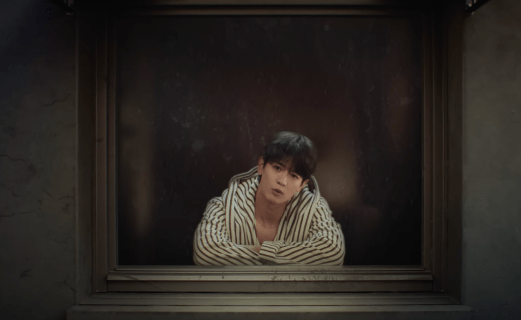 Cena do MV de "Call Back", que marca o comeback do Minho do SHINee com seu primeiro álbum. Na imagem, Minho está debruçado em uma janela enquanto olha para a câmera
