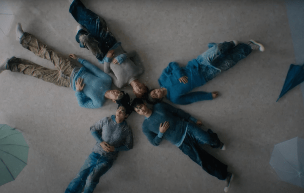 Cena do MV de "Over the Moon" do álbum The Star Chapter: SANCTUARY com todos os membros do TXT deitados com o ângulo da câmera visto de cima