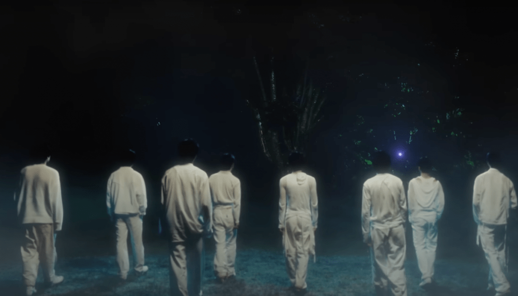 Cena do MV de "UNIVERSE" do álbum Youth Chapter 2: YOUTH DEFICIENCY do EPEX com todos os membros de costas indo em direção a um lugar misterioso