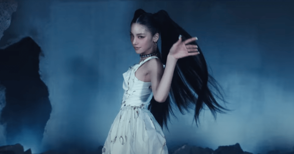 Cena do MV de Air do álbum de debut solo da Yeji [Itzy]. Na imagem, ela está com um vestido branco em um cenário que parece neblina