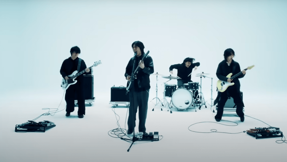 Cena do MV de Not Out, com a banda Dragon Pony e seus instrumentos em um fundo branco