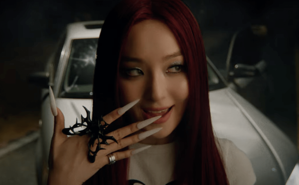 Cena do MV de Baby, Not Baby do álbum da Seulgi [Red Velvet]. Na imagem, ela está olhando para o lado com uma das mãos na boca