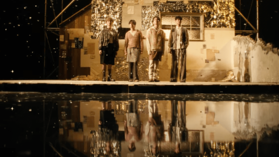 Cena do MV de Poet | Artist do SHINee em um cenário escuro, iluminando apenas por uma luz baixa e o reflexo dos quatro membros na água