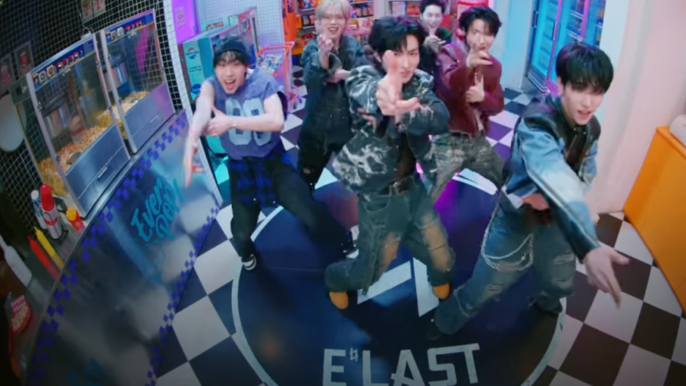 Cena do MV de "Crazy Train" do álbum Versus do E'LAST com Baekgyeul, Rano, Romin, Wonhyuk, Wonjun e Yejun dançando em um café retrô colorido