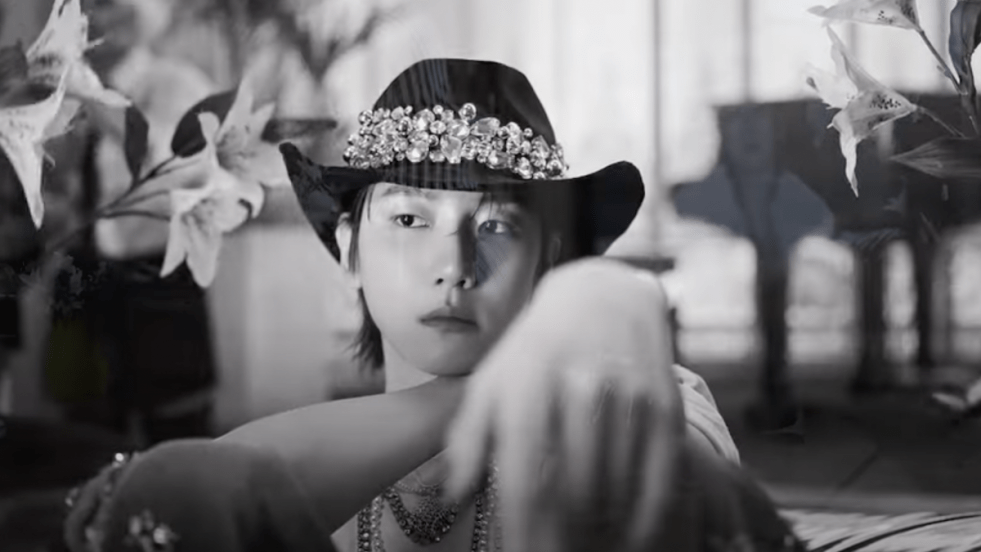 Cena do MV de Elevator do álbum Essence of Reverie do Baekhyun. Imagem em preto e branco com Baekhyun no centro, sentado e olhando para o lado