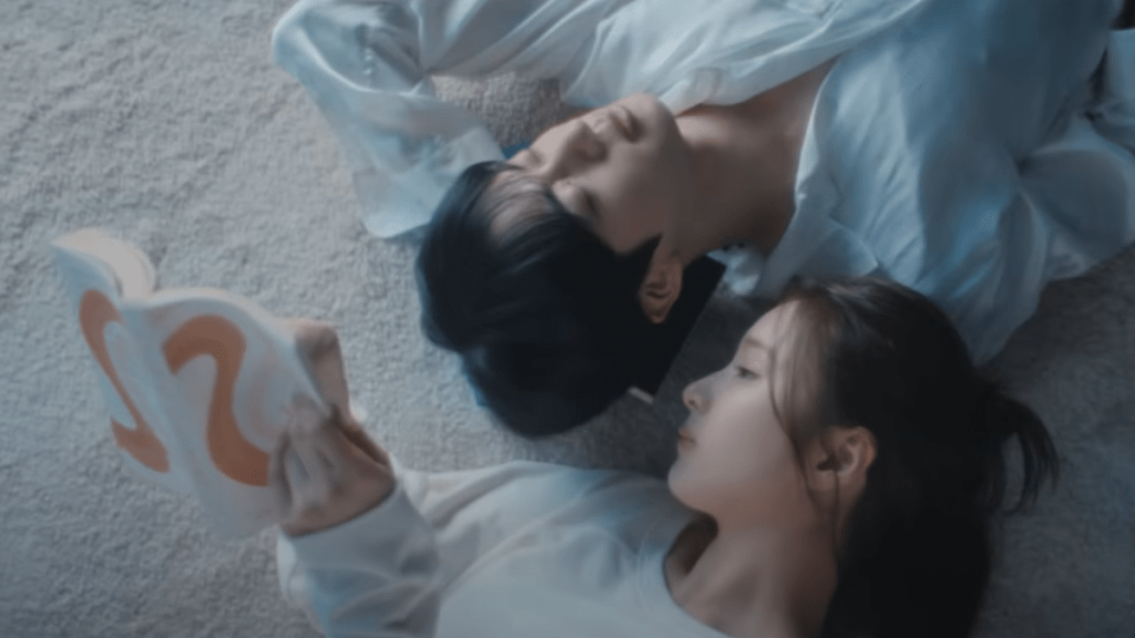 Cena do MV de "Don't Say You Love Me" do álbum Echo com Jin (BTS) e a atriz Shin Se-kyung de branco e deitados um ao lado do outro