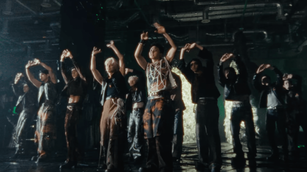 Cena do MV de "THUNDER" do álbum HAPPY BURSTDAY do SEVENTEEN com todos os membros dançando o refrão em um cenário escuro